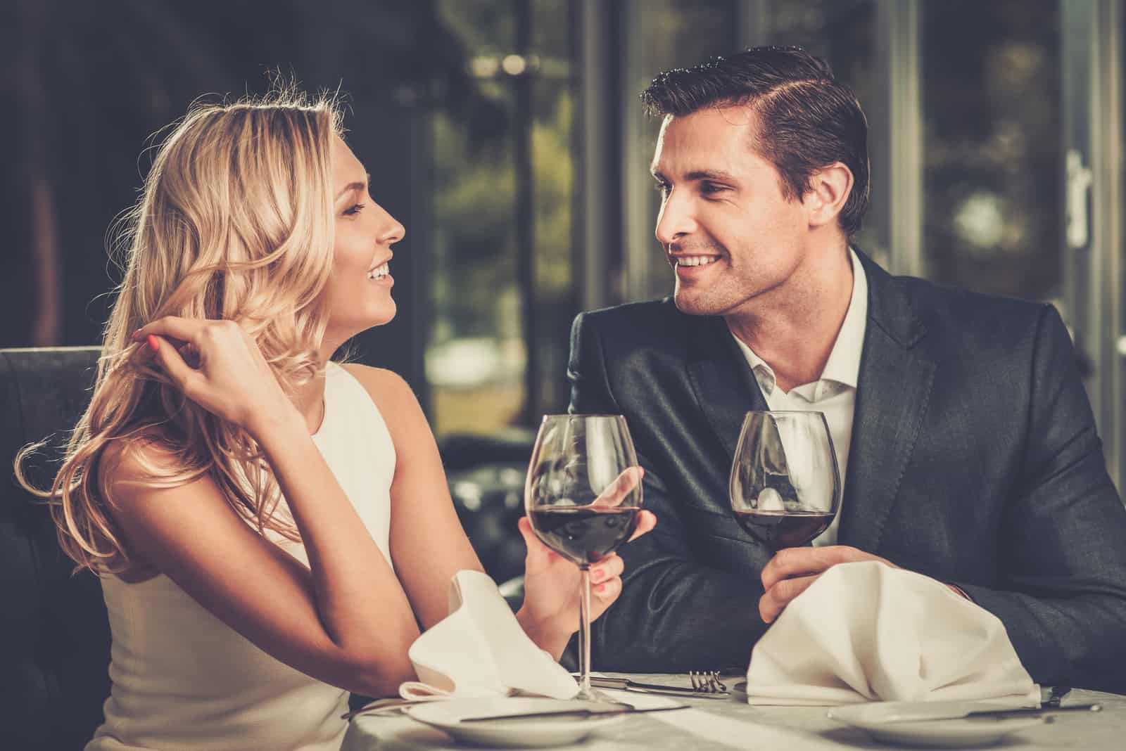زوجان مرحان في مطعم مع كؤوس من النبيذ الأحمر