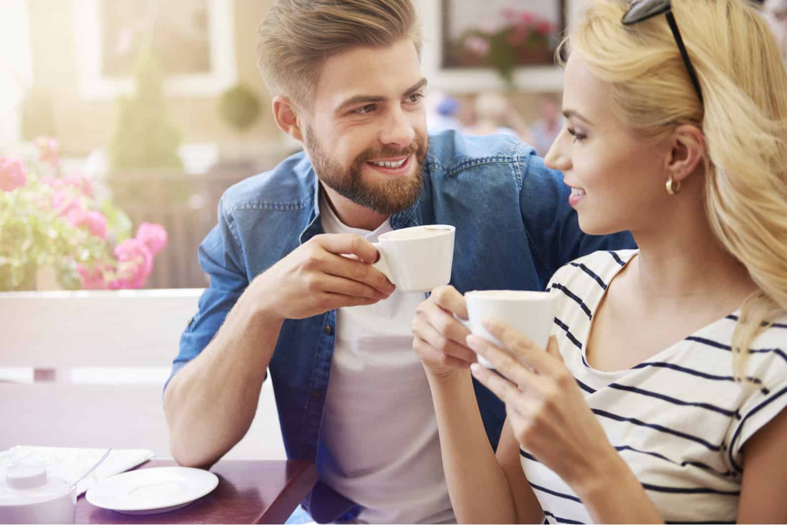 رجل وامرأة يشربان القهوة وينظران إلى بعضهما البعض
